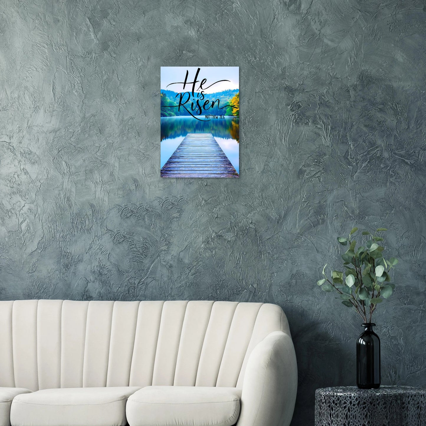 Wall art with 'He is Risen' text over a lake scene in a living room setting.
