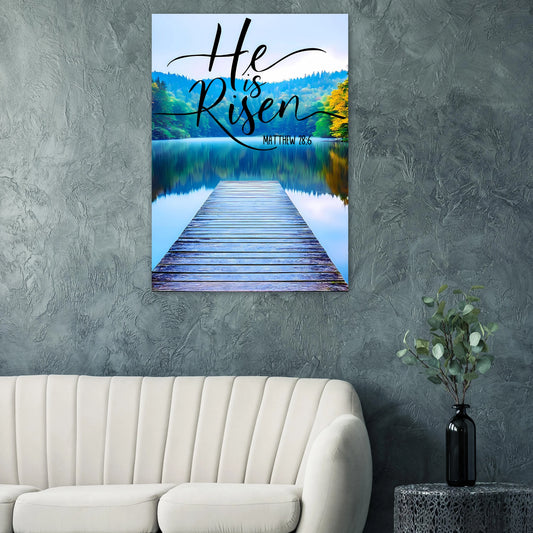 Canvas print with 'He is Risen' text over a dock scene on a wall above a sofa.